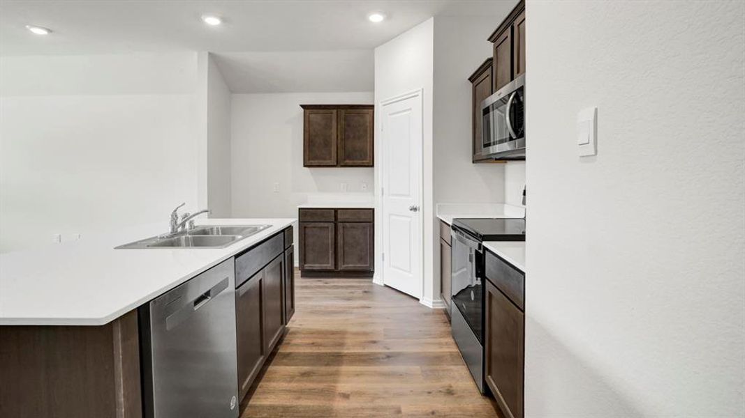 Kitchen featuring an island with a double basin sink and stainless steel dishwasher