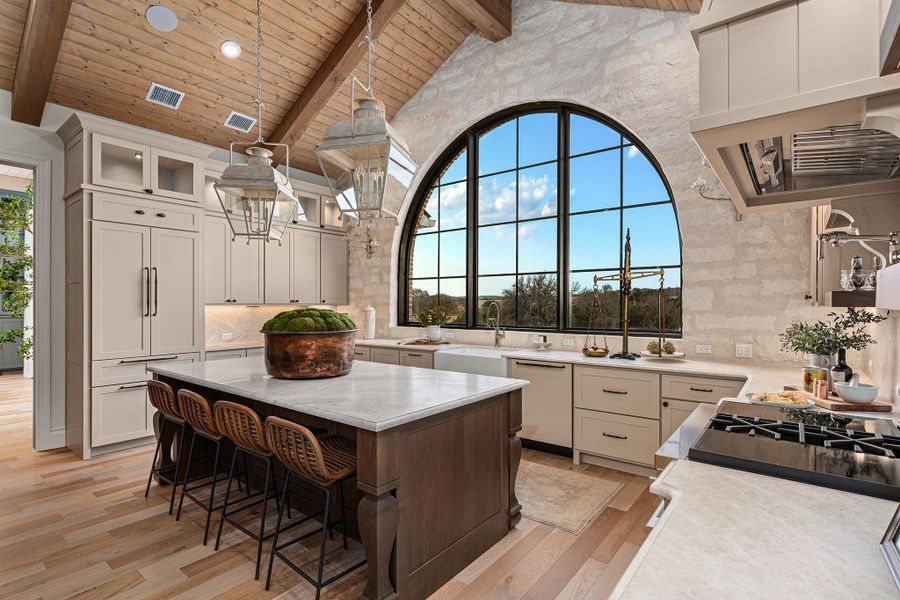 Kitchen featuring a kitchen bar, custom range hood, a wooden ceiling with exposed beams, a kitchen island, and dishwashing machine
