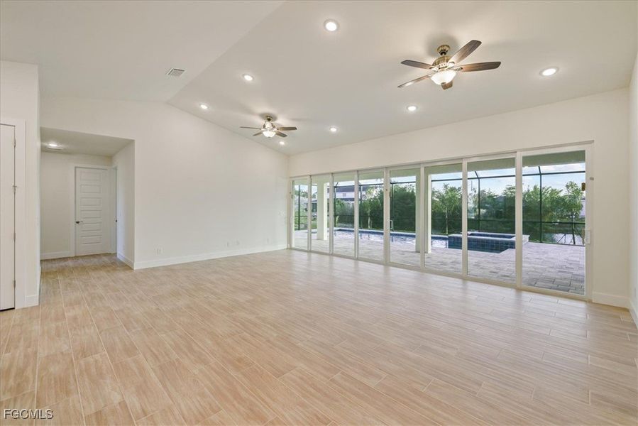 Spare room with vaulted ceiling, recessed lighting, wood tiled floors, and ceiling fan