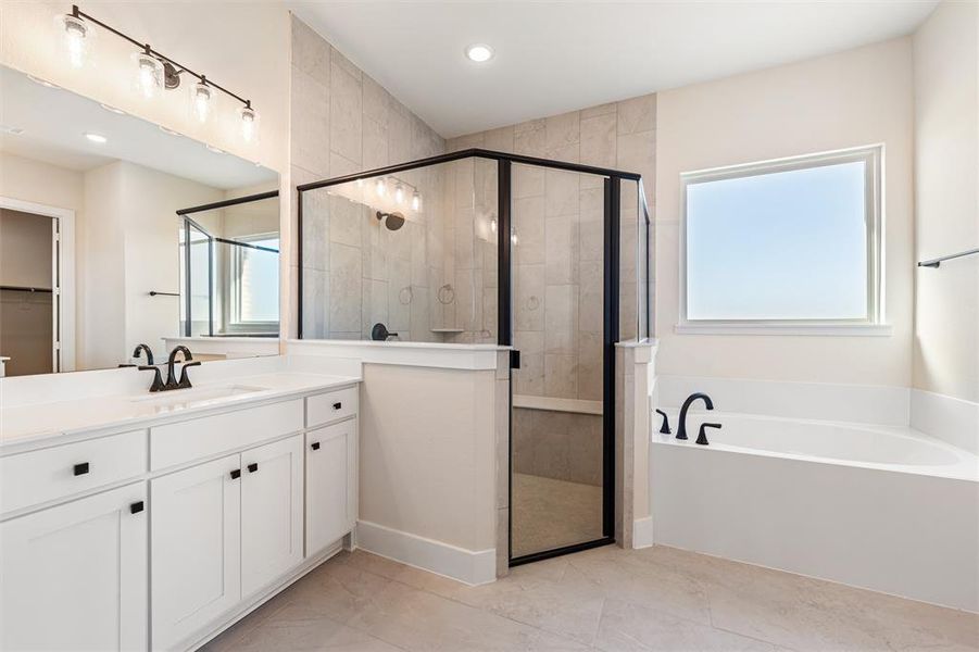 Full bathroom featuring a garden tub, vanity, and a shower stall