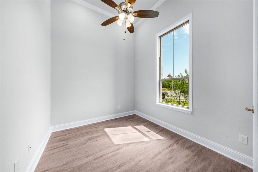 Study with crown molding, luxury vinyl flooring, large window, and ceiling fan Study with crown molding, luxury vinyl flooring, large window, and ceiling fan