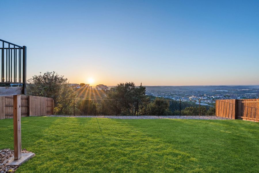 Expansive green lawn with a black metal fence bordering the property Expansive green lawn with a black metal fence bordering the property
