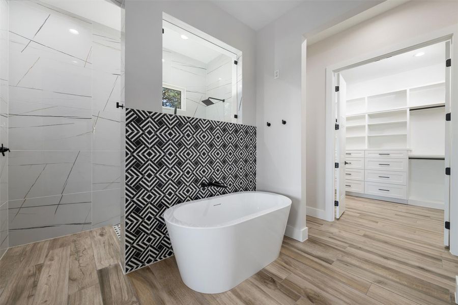 Bathroom with hardwood / wood-style floors and separate shower and tub