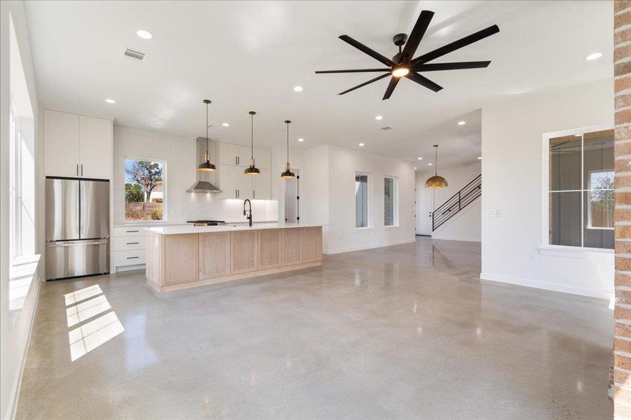 Kitchen with a large island, open floor plan, light countertops, hanging light fixtures, and recessed lighting