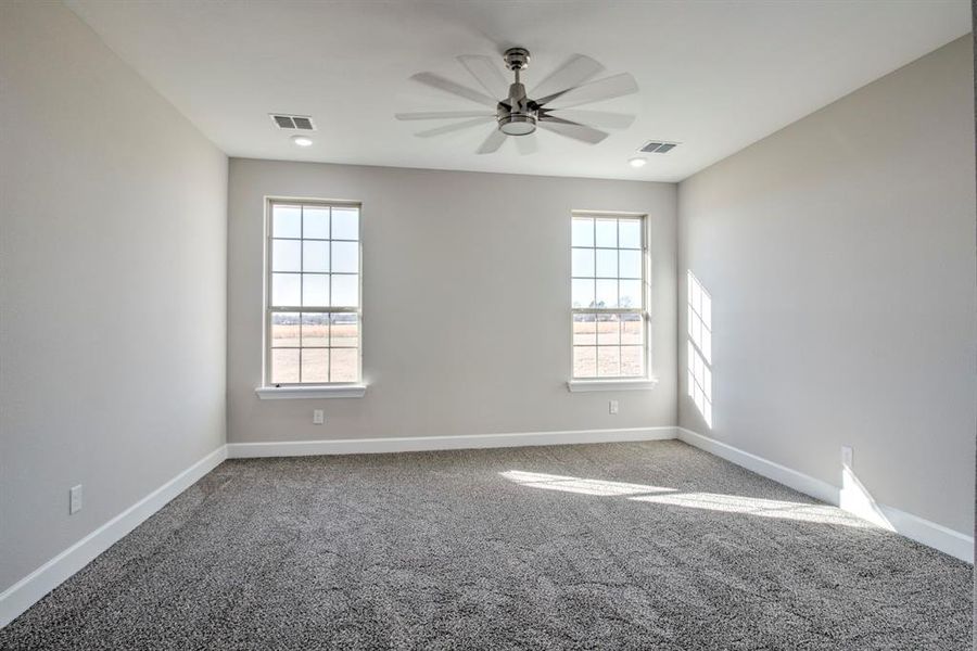 Empty room featuring carpet and a ceiling fan