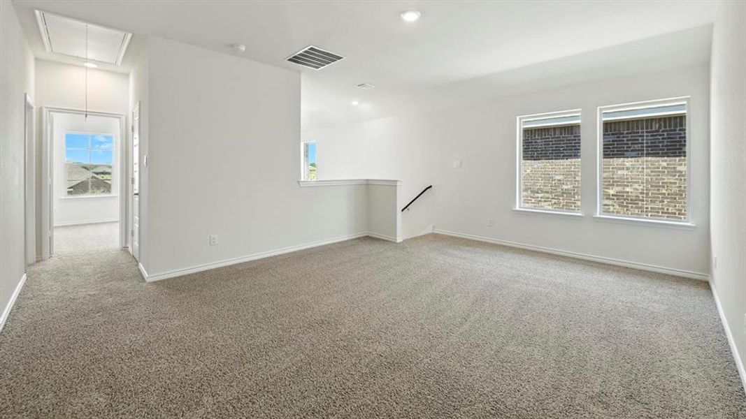 Spare room with attic access, light carpet, and recessed lighting