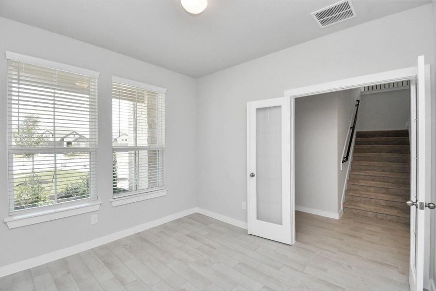 Experience the perfect blend of sophistication and warmth in this home office, boasting elegant wood-look tile flooring and flooded with natural light from expansive windows and French doors. Experience the perfect blend of sophistication and warmth in this home office, boasting elegant wood-look tile flooring and flooded with natural light from expansive windows and French doors.
