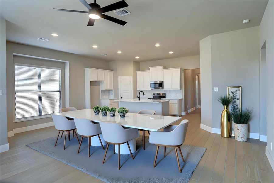 Dining room with ceiling fan, recessed lighting, and light wood-style floors