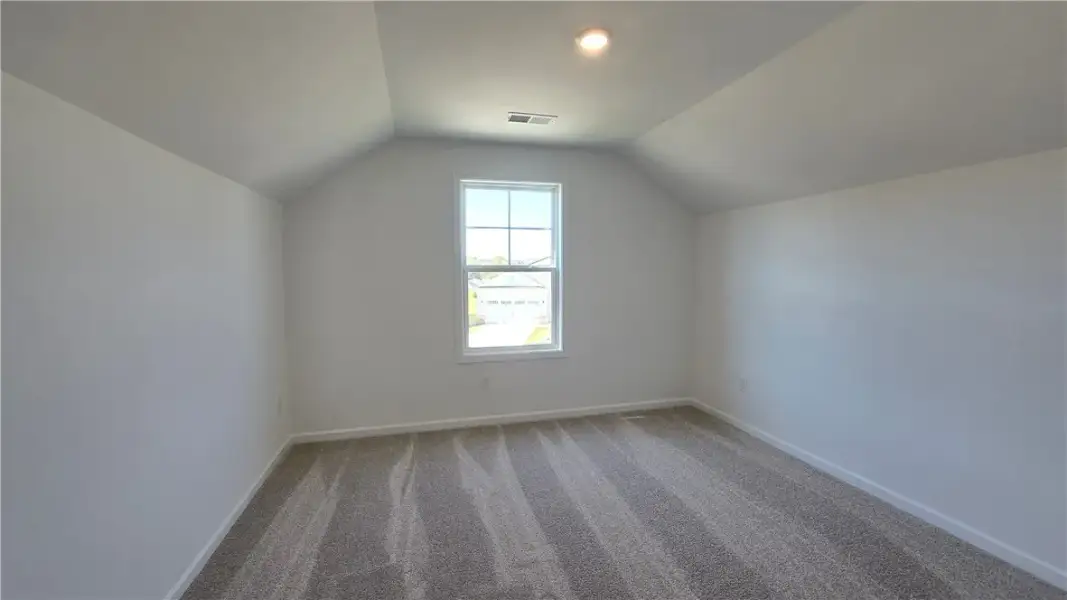 Angled ceilings frame a single window in this cozy