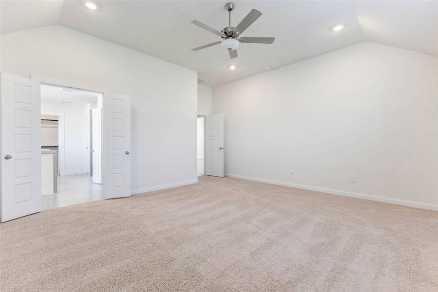 A spacious owner’s retreat with plush carpeting and neutral tones flows into a luxurious ensuite. The double-door entry leads to a private bath and walk-in closet, while the ceiling fan and recessed lights add both comfort and style to this relaxing haven. A spacious owner’s retreat with plush carpeting and neutral tones flows into a luxurious ensuite. The double-door entry leads to a private bath and walk-in closet, while the ceiling fan and recessed lights add both comfort and style to this relaxing haven.