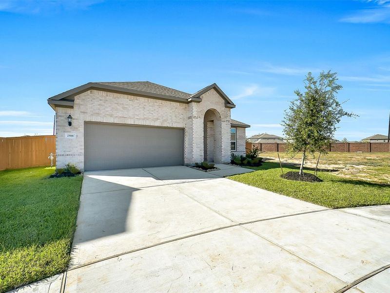 Front exterior of a new home in Sunterra, Katy, TX, highlighting curb appeal (Image 2).