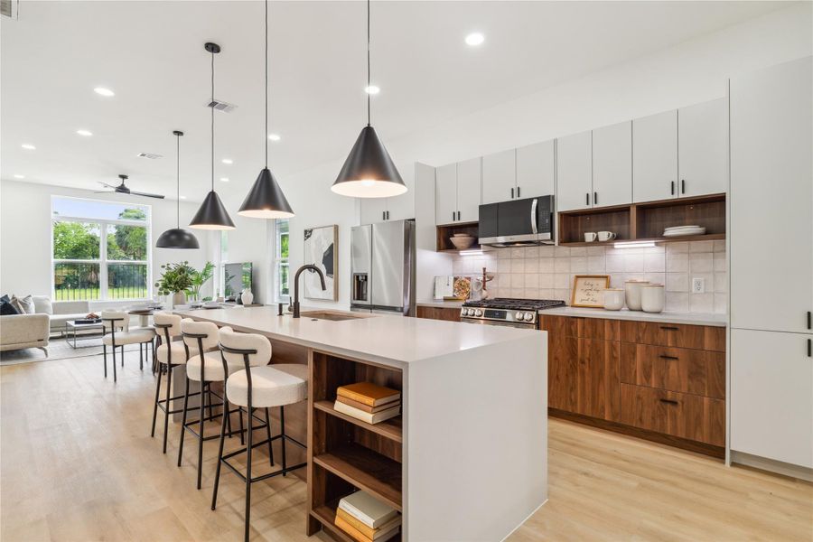 With oversized picture windows, a waterfall-edge island, and an effortless connection to the living space, this kitchen truly becomes the heart of the home. With oversized picture windows, a waterfall-edge island, and an effortless connection to the living space, this kitchen truly becomes the heart of the home.