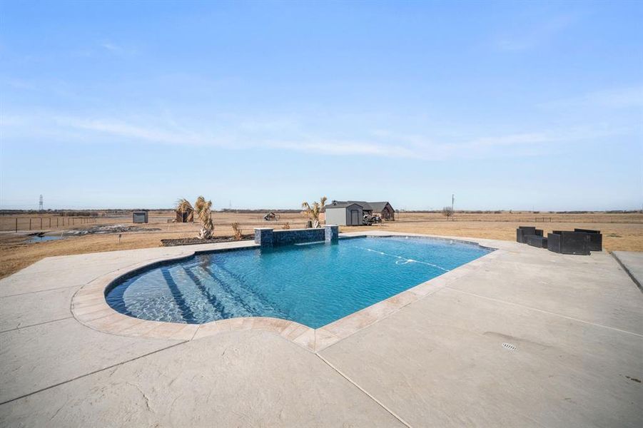 Swimming pool featuring a patio area and a storage shed