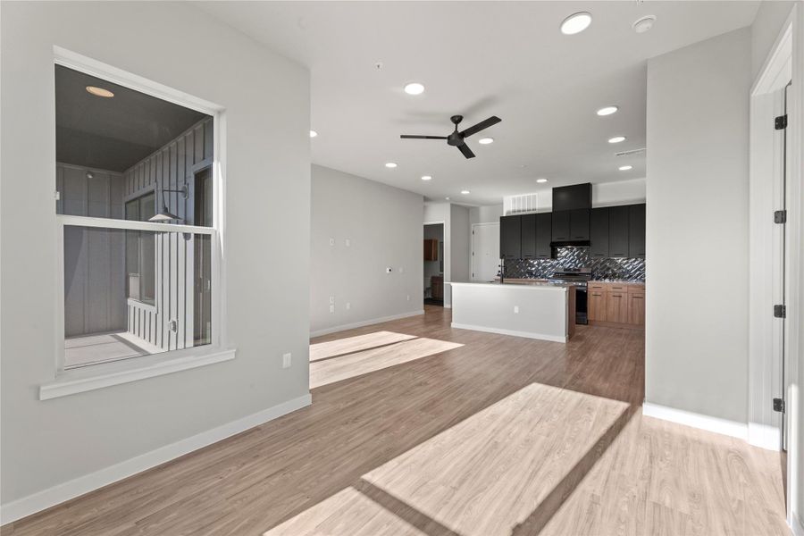 Kitchen featuring tasteful backsplash, ceiling fan, a center island, and hardwood / wood-style flooring