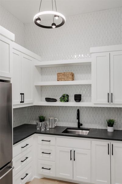 A well-appointed pantry and scullery extend the kitchen’s functionality with additional custom cabinetry, prep sink, refrigerator, and storage. A well-appointed pantry and scullery extend the kitchen’s functionality with additional custom cabinetry, prep sink, refrigerator, and storage.