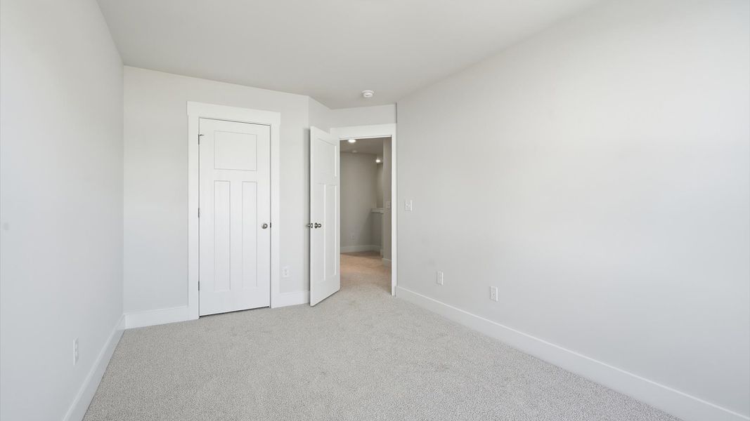 Superior comfort in a secondary bedroom with plush carpet and an oversized walk-in closet by DRB Homes