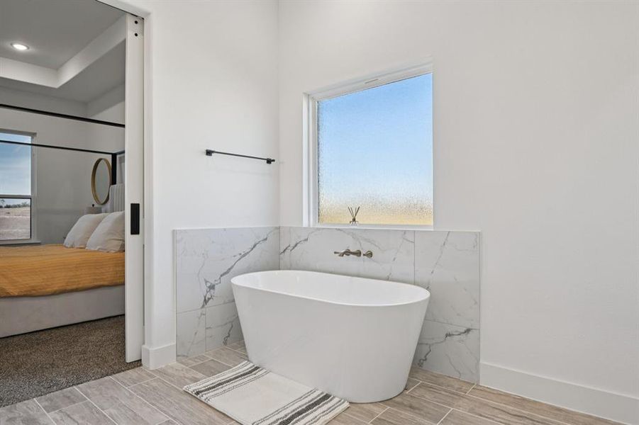 Ensuite bathroom with wood tiled floors and a soaking tub Ensuite bathroom with wood tiled floors and a soaking tub