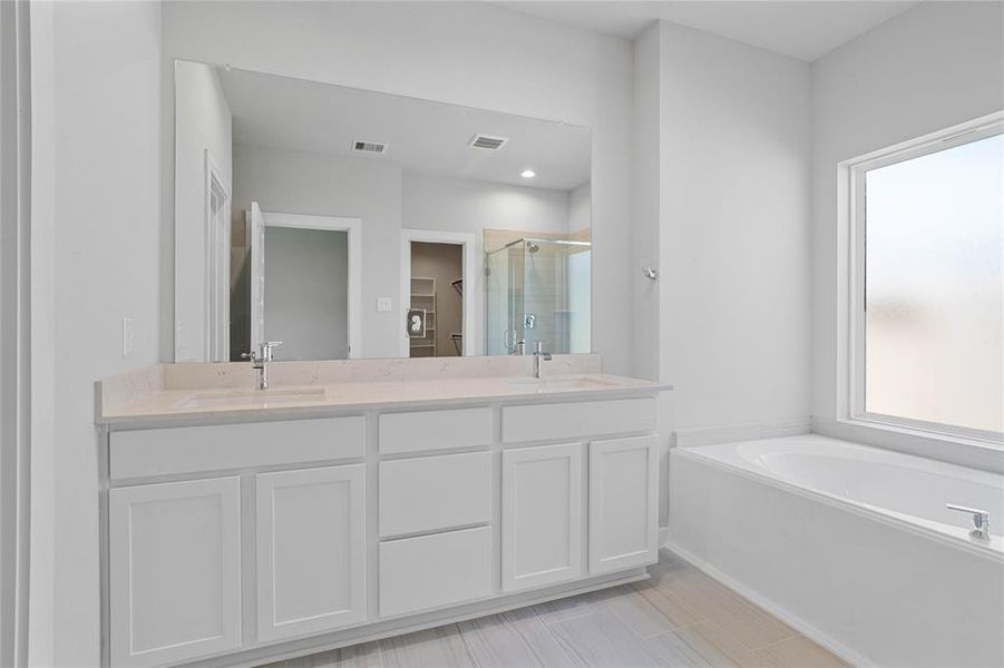 This primary bathroom is definitely move-in ready! Featuring white stained cabinets with light countertops, spacious walk-in closet with shelving, high ceilings, custom paint, sleek and dark modern finishes.