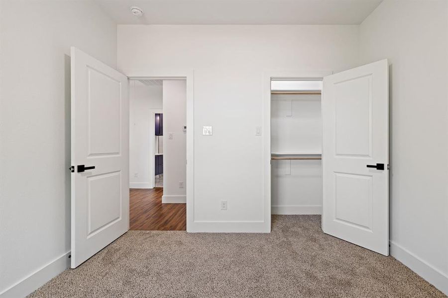 Unfurnished bedroom featuring carpet floors and a spacious closet