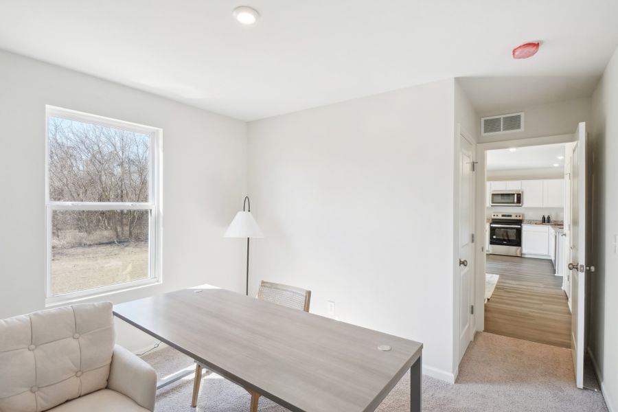A living room with a table and chairs. A living room with a table and chairs.