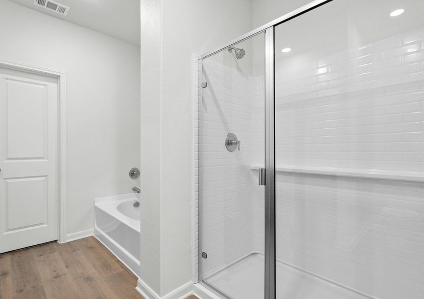 The master bathroom has a glass, walk-in shower and garden tub.