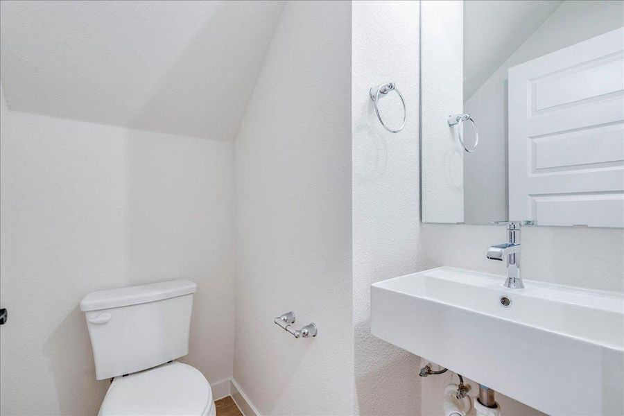 A compact and functional bathroom featuring a clean white vanity and toilet.
