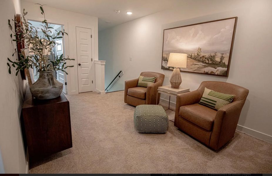 Carpeted room featuring light neutral wall paint, white trim, and a white interior door with a black handle