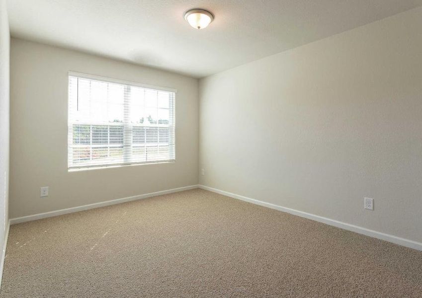 Hartford bedroom with large window, brown carpet, and off white walls