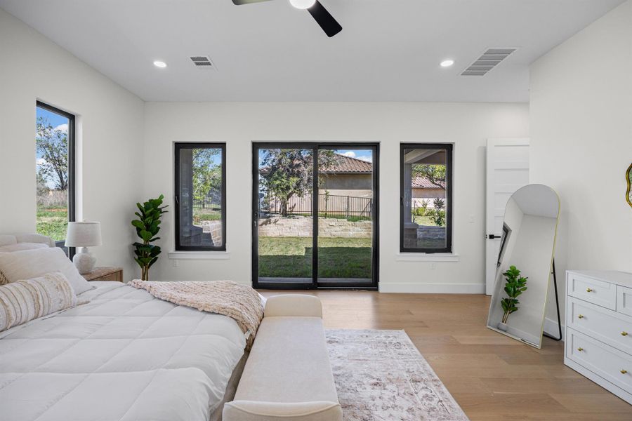 Bedroom featuring light wood-type flooring, multiple windows, ceiling fan, access to exterior, and recessed lighting