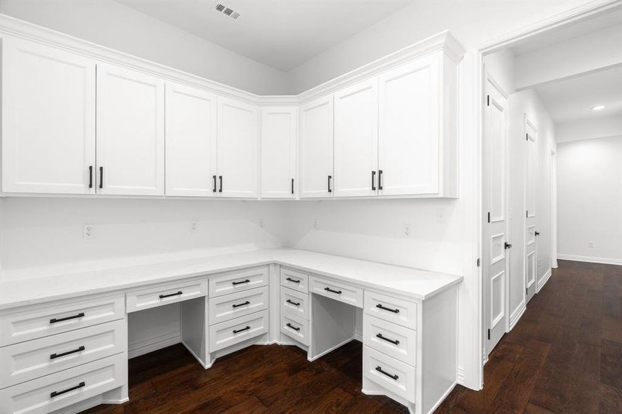 Unfurnished office featuring built in study area, dark wood-type flooring, and recessed lighting Unfurnished office featuring built in study area, dark wood-type flooring, and recessed lighting