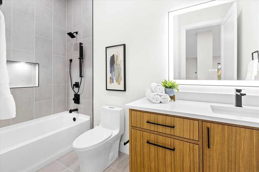 Full bathroom with vanity, tiled shower / bath combo, toilet, and tile patterned floors