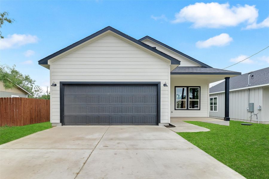 Ranch-style house featuring concrete driveway and a garage