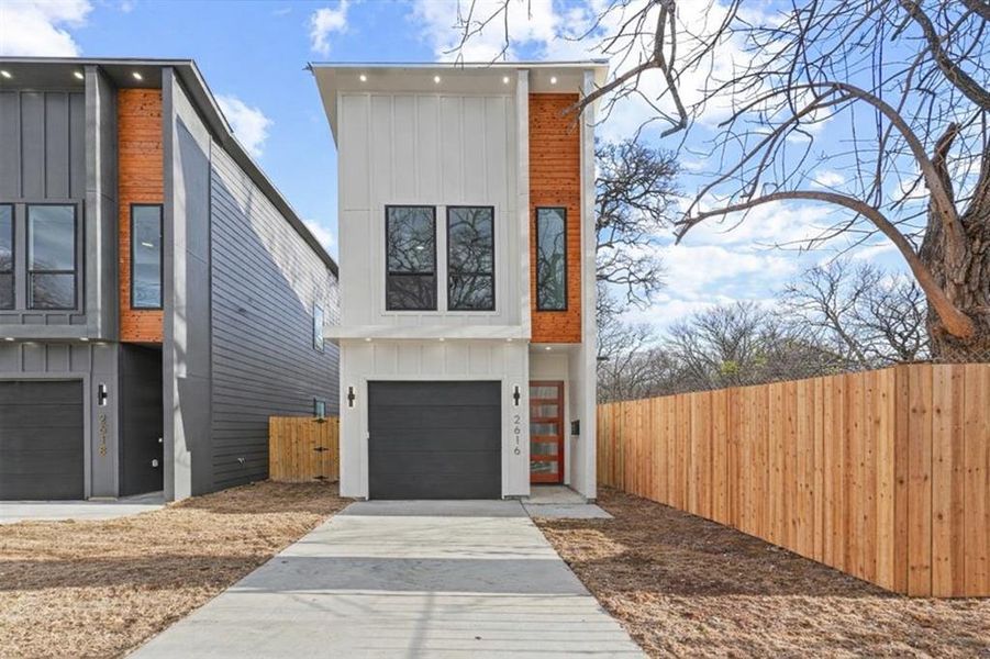Contemporary house featuring board and batten siding, a garage, and concrete driveway Contemporary house featuring board and batten siding, a garage, and concrete driveway
