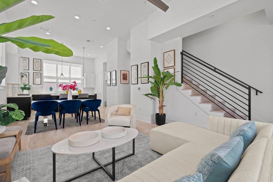 An open floorplan seamlessly connects the well-lit living area with the adjacent dining and kitchen spaces, offering a spacious and integrated feel. An open floorplan seamlessly connects the well-lit living area with the adjacent dining and kitchen spaces, offering a spacious and integrated feel.