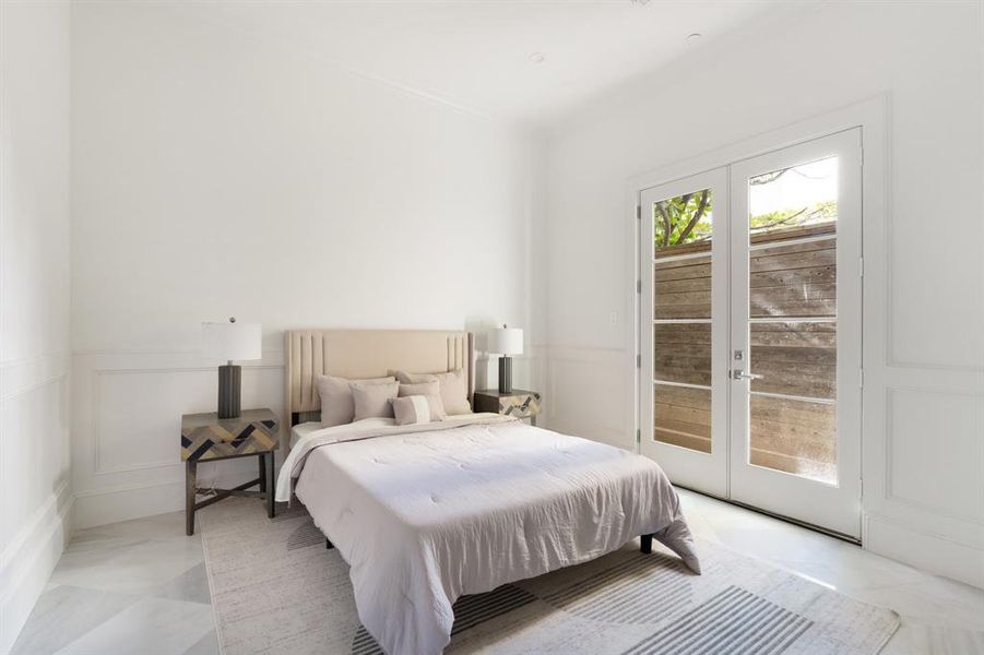 The ground floor bedroom has a large ensuite bathroom with attached closet and french door access to the back grassy area. (photo of interior model home with smaller floor plan)