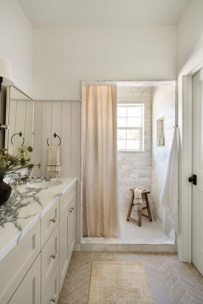 Bathroom with tiled shower and vanity