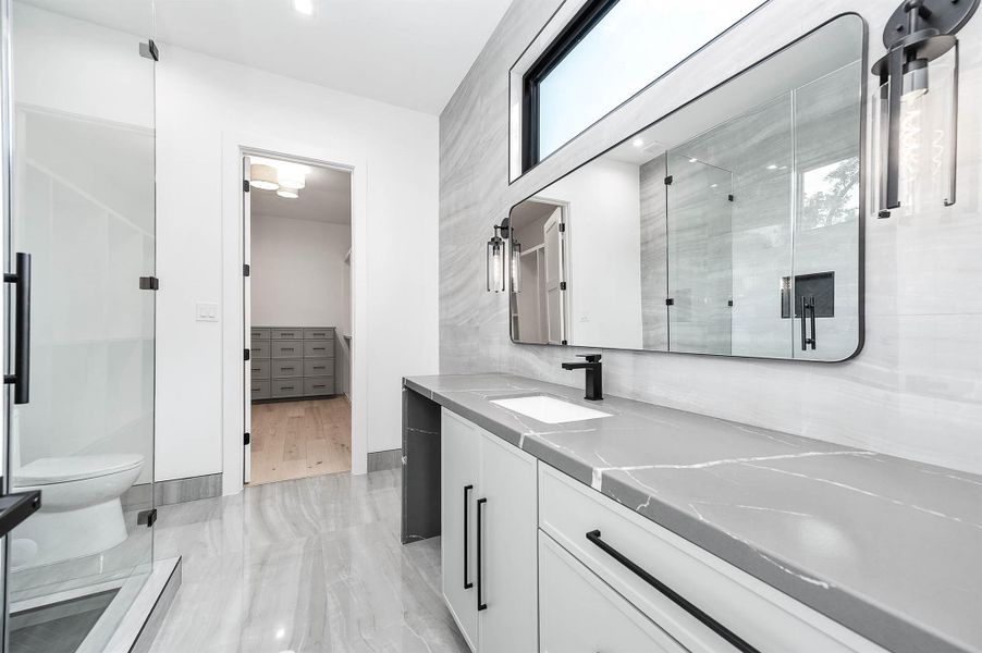 En suite bathroom featuring a vanity with a dedicated seating area.