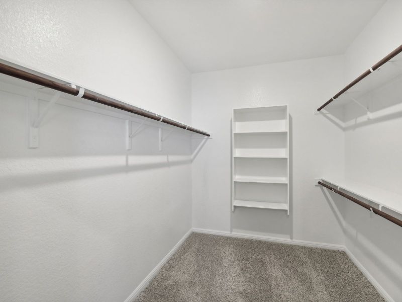 The large primary bedroom closet has plenty of space for clothes and storage.