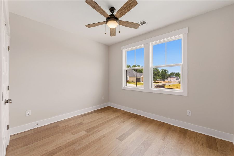 A quiet bedroom with robust wood flooring and abun