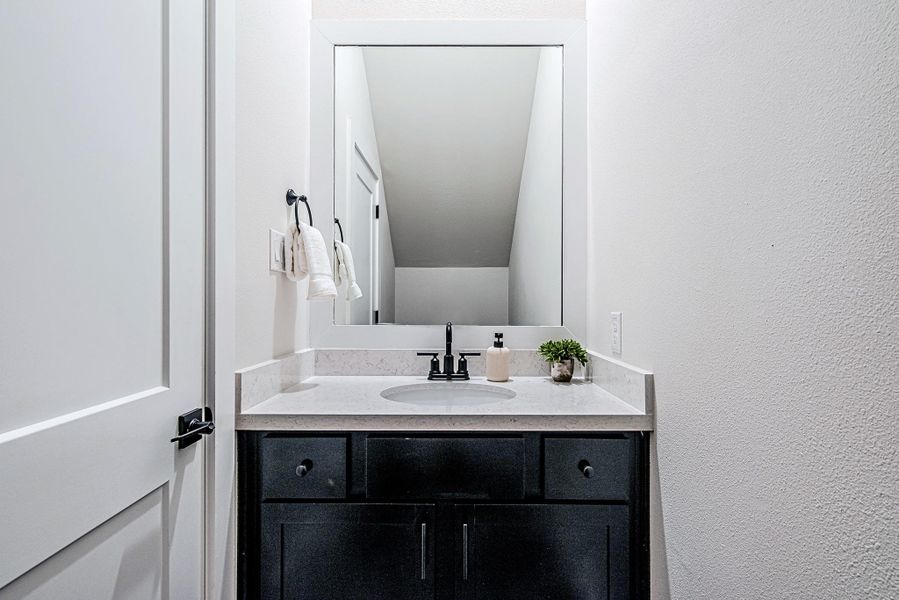 Stylish powder room with a dark vanity and modern finishes