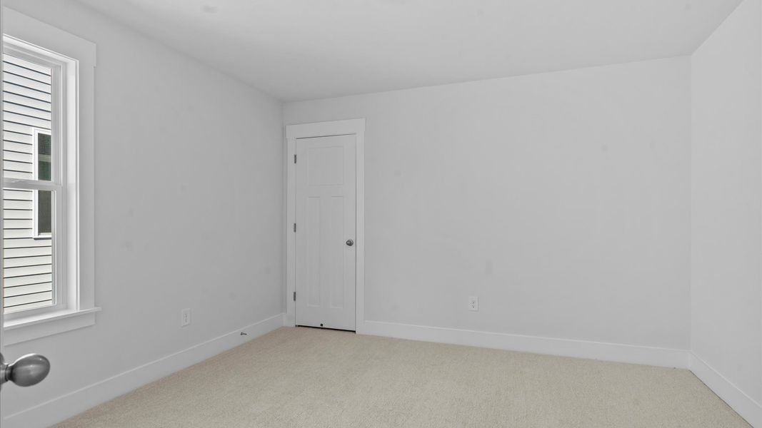 Highly functional bedroom with walk-in closet and tasteful carpet for a restful retreat