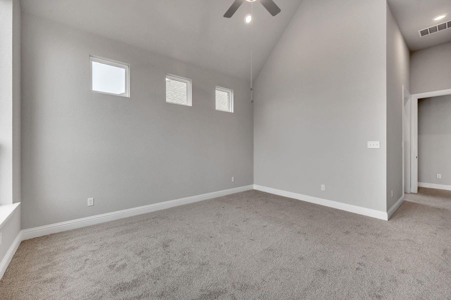 Spare room with baseboards, carpet floors, visible vents, and a ceiling fan Spare room with baseboards, carpet floors, visible vents, and a ceiling fan
