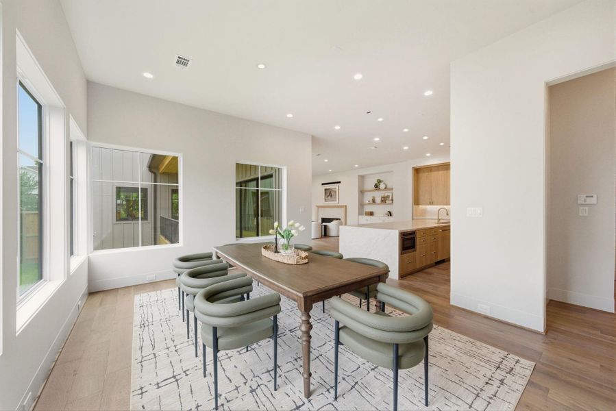 Minimalist dining design with oversized windows and warm contemporary finishes throughout.
