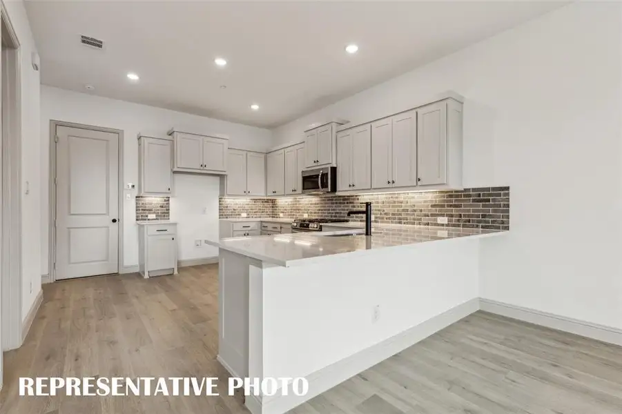 The kitchen features an large peninsula perfect for a quick meal or homework station.  REPRESENTATIVE PHOTO