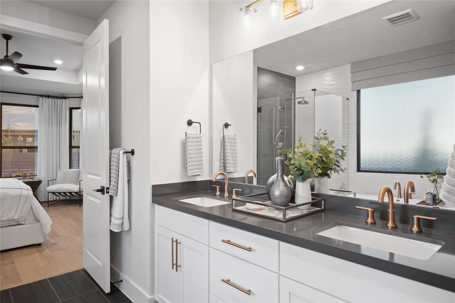 Ensuite bathroom with a stall shower, double vanity, a ceiling fan, and dark wood-style floors