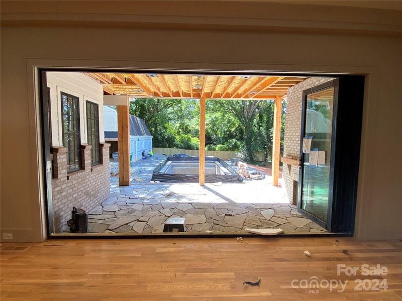 During construction shot from Living area to covered porch with slate floor and inground pool