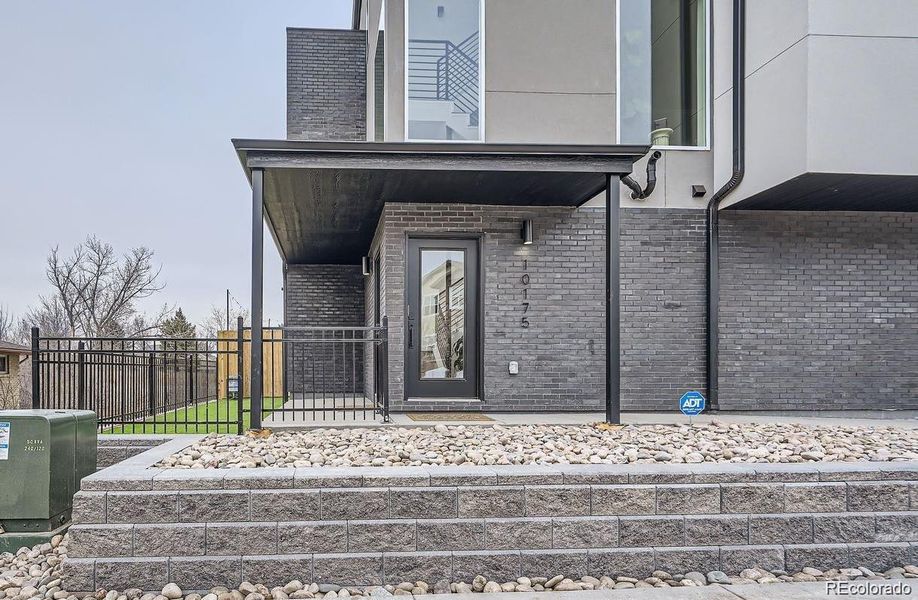 Entry to one of the other homes. Landscape bushes are installed.