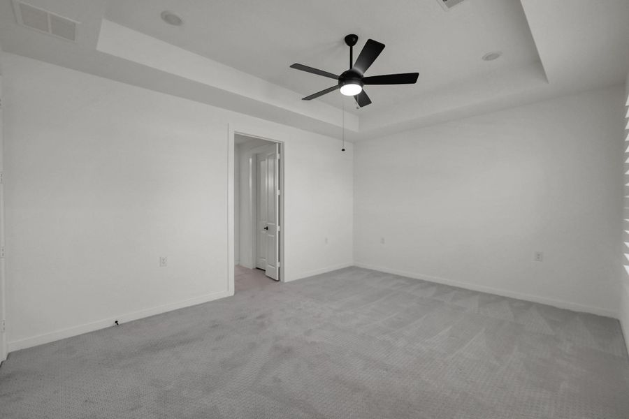 This room features patterned carpet, recessed lighting and a ceiling fan.