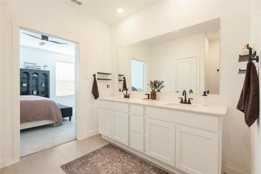 Dual vanity with white shaker cabinetry, white countertop, and black hardware Dual vanity with white shaker cabinetry, white countertop, and black hardware