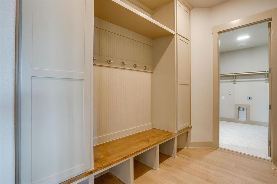 Mudroom featuring light wood finished floors and baseboards